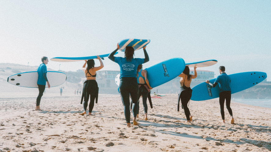 Jóvenes haciendo surf en la playa.